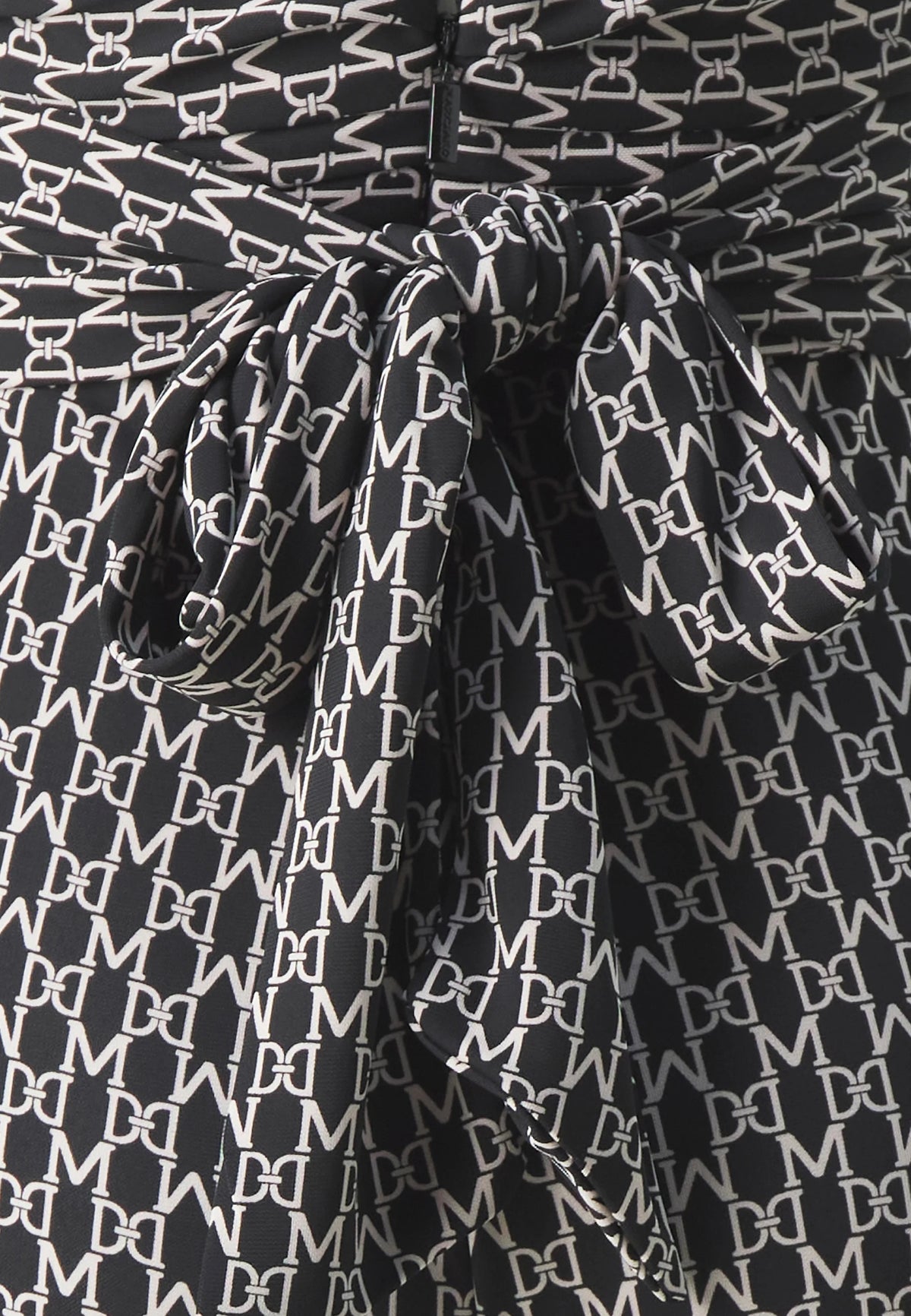 Close-up of the fabric detail of the Marciano by Guess New Kiki Jumpsuit – Black featuring elegant printed design.